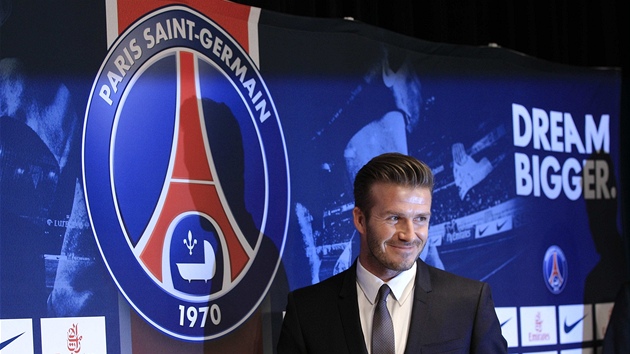 S NOVM LOGEM. David Beckham pzuje fotografm po podpisu smlouvy s Paris St. Germain.  