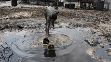 Mu nabírá vodu ve zneitné oblasti blízko eky Nun v Nigérii (ilustraní
