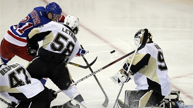 Tomá Vokoun z Pittsburghu zasahuje ped Derekem Stepanem z NY Rangers. Tomu