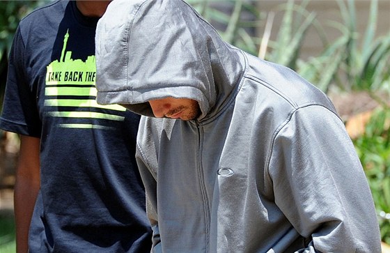 Policisté odvádjí atleta Oscara Pistoriuse (v kapuci) z policejní stanice v