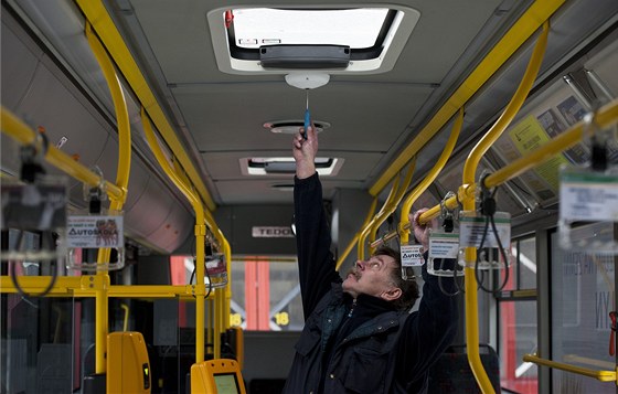 Jeden z pracovník dopravního podniku ukazuje nainstalovanou kameru v autobuse