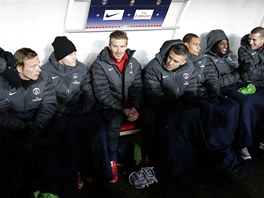 Záloník David Beckham sedí na lavice náhradník mezi svými spoluhrái z Paris...