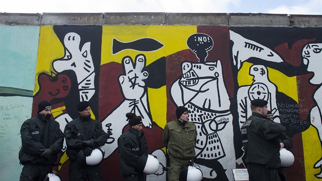 Policist hldaj st Berlnsk zdi, kterou stavai bourali, ped nespokojenmi demonstranty. 