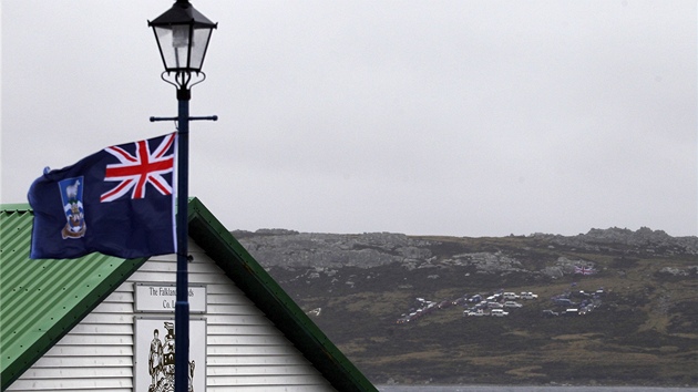 Vlajka Falklandskch ostrov vlaje na sloupu ve mst Stanley na Falklandch. V pozad je vidt zaparkovanmi auty vytvoen slovo Yes, (esky "ano") v pedveer referenda. (9. bezna 2013)