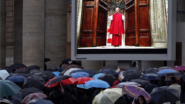 Lid na nmst sv. Petra ve Vatiknu sleduj v pmm penosu papeskho ceremonie Guida Mariniho, jak zavr dvee Sixtinsk kaple, kde se seli kardinlov, aby zvolili novho papee, nsledovnka Benedikta XVI. (12. bezna 2013)