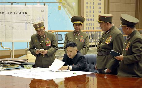 Fotografie z krizového jednání Kim ong-una a armádních velitel KLDR. Mapy v