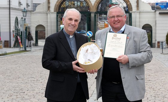 Plzeský biskup Frantiek Radkovský drí pouzdro s pivním pohárem pro papee Frantika I. Starí obchodní sládek Václav Berka ukazuje certifikát stvrzující, e do Vatikánu míí z Plzn poehnaný zlatý mok.