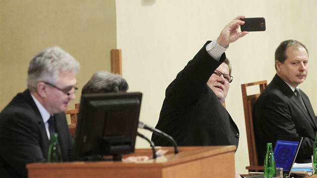 Zdenk kromach (SSD) si fot na mobiln telefon projev prezidenta Miloe Zemana k sentorm. (21. bezna 2013)
