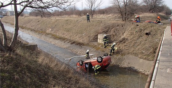 Havarované auto z potoka vytáhli hasii.