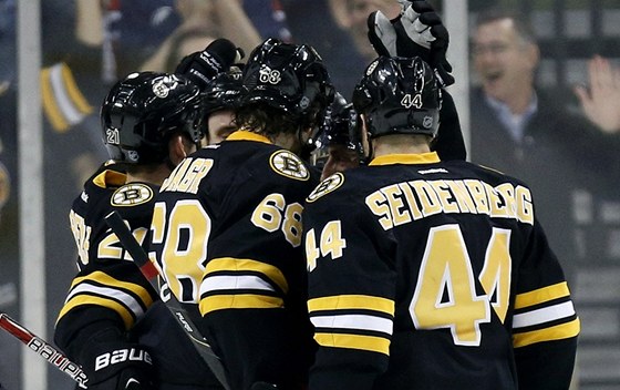 Bostontí hokejisté se radují z gólu Brada Marchanda, asistoval u nj i Jaromír
