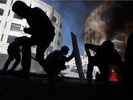 SMRT. Palestinci prohledávají ruiny bhem boj s izraelskými vojáky v Hebronu....