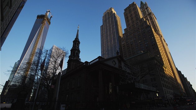 Paprsky vychzejccho slunce prv dopadaj na prosklenou fasdu newyorskho mrakodrapu One World Trade Center.