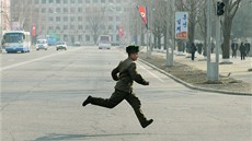 Severokorejský voják utíká ulicemi Pchjongjangu (14. dubna 2013)