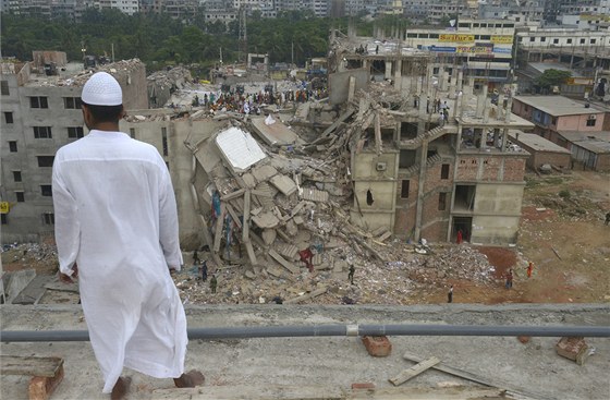 Bangladéan se dívá na místo netstí, kde se zítila osmipatrová budova (27....