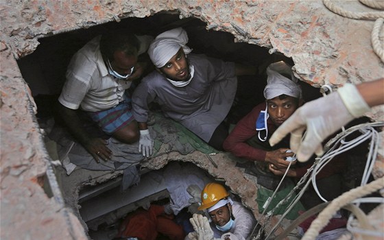 Bangladétí záchranái se snaí vyprostit z trosek zíené budovy peiví...