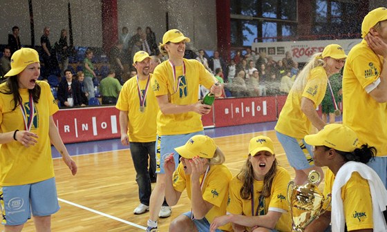 Basketbalistky a realizaní tým USK Praha slaví se ampaským zisk mistrovského