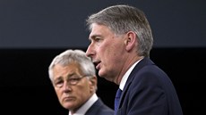 Chuck Hagel (v pozadí) a Philip Hammond hovoří na tiskové konferenci v... Chuck Hagel (v pozadí) a Philip Hammond hovoří na tiskové konferenci v...