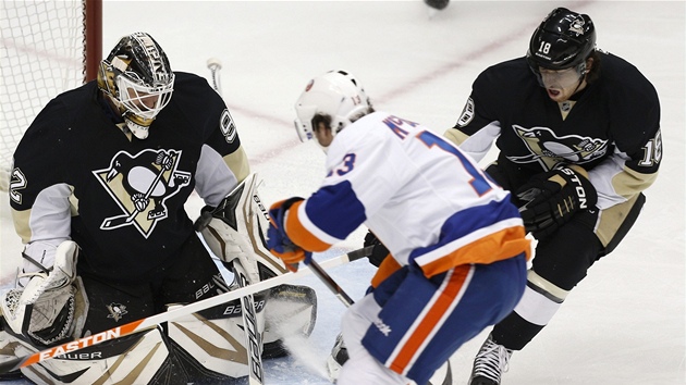 Tom Vokoun z Pittsburghu zasahuje proti Colinu McDonaldovi z NY Islanders. Vpravo tonk James Neal.