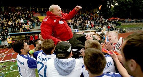 Fotbalisté Znojma slaví postup, do vzduchu létá trenér Leo Kalvoda. 