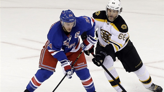 Ryan Callahan z New York Rangers je pi rozehrvce pod tlakem, dotr ne nj Jaromr Jgr z Bostonu. 