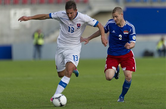 Slovenský útoník Filip Holoko pádí s míem, v patách mu je Yves Oehri. Tento