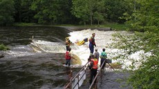 Záchranái se snaí vyprostit raft, na kterém se pt vodák pevrhlo na