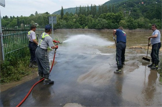 Hasii odklízejí a splachují bahno ze silnic u dom ve Vaov na Ústecku. (13.