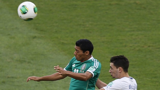 Hlavikov souboj v podn mexickho fotbalisty Javiera Aquina (vlevo) a Itala Mattia De Sciglia. 