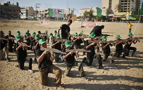 Chlapci cvií na táboe poádaném Hamásem s devnými zbranmi.