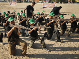 Chlapci cvií na táboe poádaném Hamásem s devnými zbranmi.