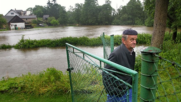 Frantiek Wimmer sleduje rozvodnnou Doubravu v obci Blek u Chotboe. (25. ervna 2013)