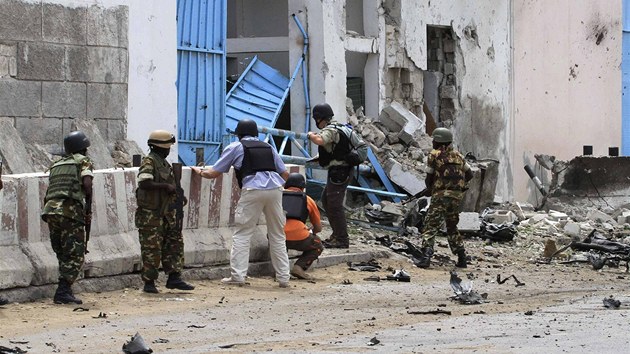 Vyetovatel a vojci ped komplexem OSN v Mogadiu, na kter zatoili terorist. Po vbuchu auta a toku ozbrojenc zahynulo nejmn 22 lid.