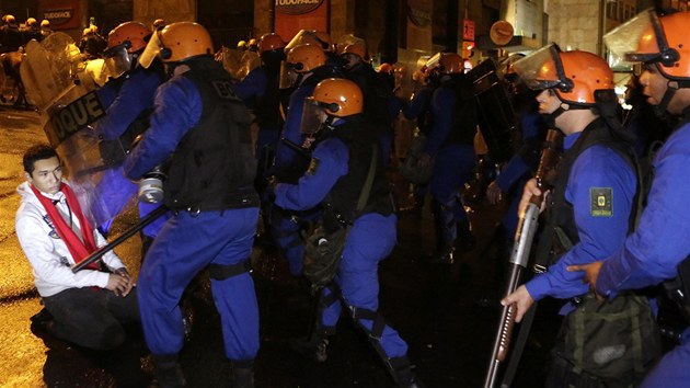 Demonstrant klec na zemi brn postupu policejnho kordonu v pondl 24. ervna v Porto Alegre.