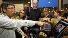 Novinái na letiti v Moskv ukazují pasaérm letu z Hongkongu Snowdenovu...