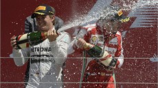 CHAMPAGNE SHOWER. Vítz Nico Rosberg a tetí Fernando Alonso po Velké cen