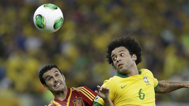 panlsk fotbalista Pedro Rodriguez (vlevo) a Marcelo z Brazlie v hlavikovm souboji.