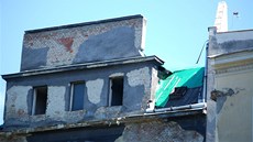 Ze stechy bývalého módního domu vyrstají keíky, na fotografii pohled na elní stranu budovy stojící na nároí ulic 28. íjna a Nádraní. (2. ervence 2013)