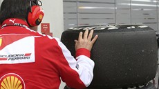 Mechanik ze stáje Ferrari kontroluje pneumatiky znaky Pirelli.