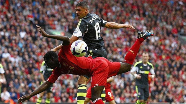 GYMNASTIKA. Souboj o m bhem zpasu Liverpoolu proti Stoke City. Kolo Toure z Liverpoolu (v ervenm) pad na zem, Jonathan Walters stabilitu udrel.