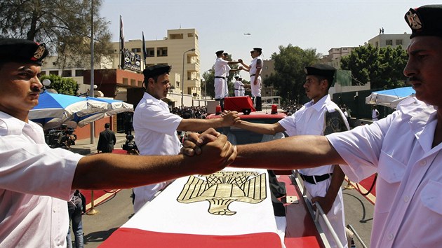 Egyptt policist na pohbu vzdvaj hold svm kolegm, kte zahynuli pi stedench nepokojch v Khie (15. srpna 2013).