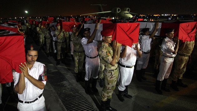 Pslunci egyptsk armdy a policie nesou spolen rakve s tly policist zabitch v pondl na Sinajskm poloostrov (19. srpna 2013).