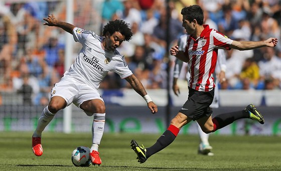 B̎Í ZBYTEN. Marcelo z Realu Madrid (vlevo) kontroluje mí ped Carlosem...
