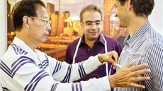 Krejí Liu (vlevo) a Sandy (uprosted) berou míru eskému zákazníkovi. Oblek mu...