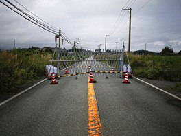 Píjezdovou cestu do msta Namie v prefektue Fukuima blokuje policejní