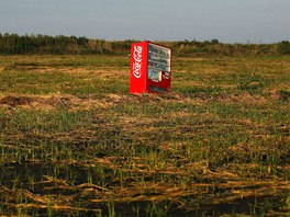 A vending machine, brought inland by a tsunami, is seen in a abandoned rice...