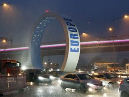 Cars drive through a flooded street near the airport during heavy rain in the...