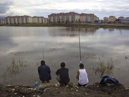 Builders from Yerevan, Akop, Artyom and Kenrikh (L-R) fish in a pond outside...
