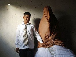 Young Palestinian groom Ahmed Soboh, 15, and his bride Tala, 14, stand inside...