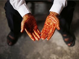 Young Palestinian groom Ahmed Soboh, 15, shows traditional henna designs on his...