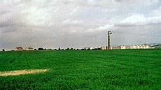 Zliín, zaátek 90. let, zelená louka. V dálce rostoucí sídlit Stodlky